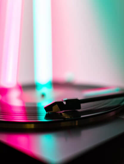 A turntable lit in pink and teal